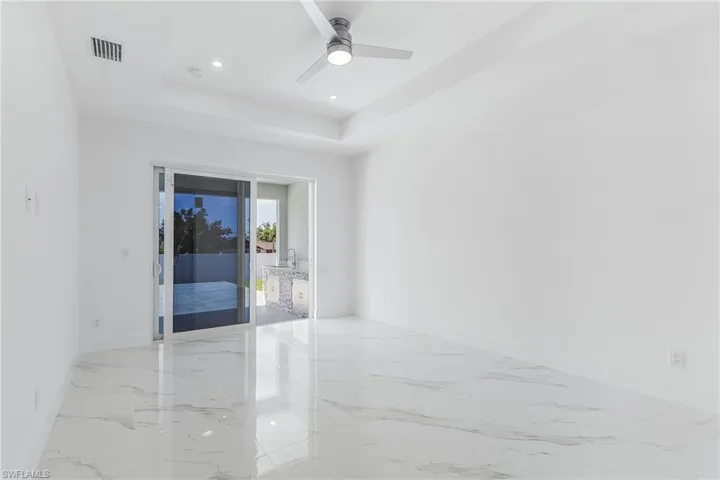 Spare room with visible vents, baseboards, a tray ceiling, recessed lighting, and marble finish floor