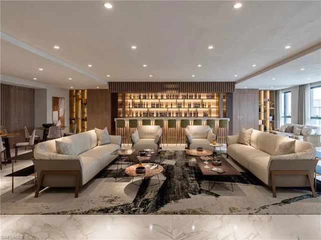 Built-in bar featuring wood-slat detailing, integrated display shelving, recessed lighting, and stone-finish flooring throughout. Developer Rendering