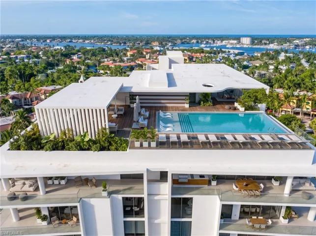 Rooftop terrace featuring a swimming pool, wood-finish decking, structural pergola, integrated planters, and an outdoor kitchen with grill. Developer Rendering