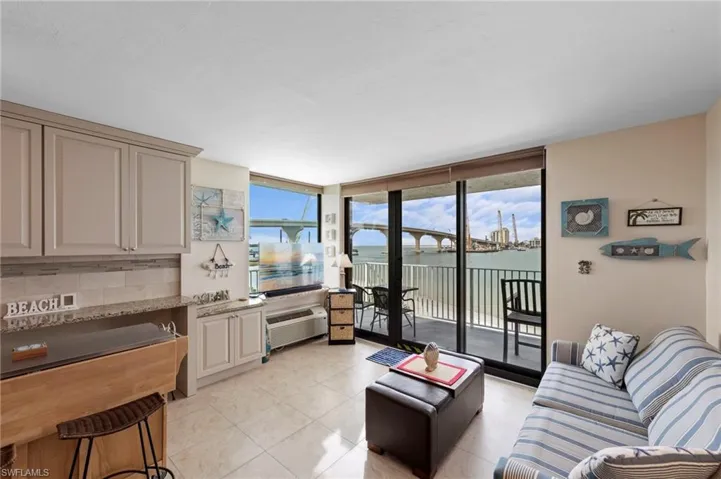 Living room featuring expansive windows, light tile patterned flooring, french doors, and a wall unit AC