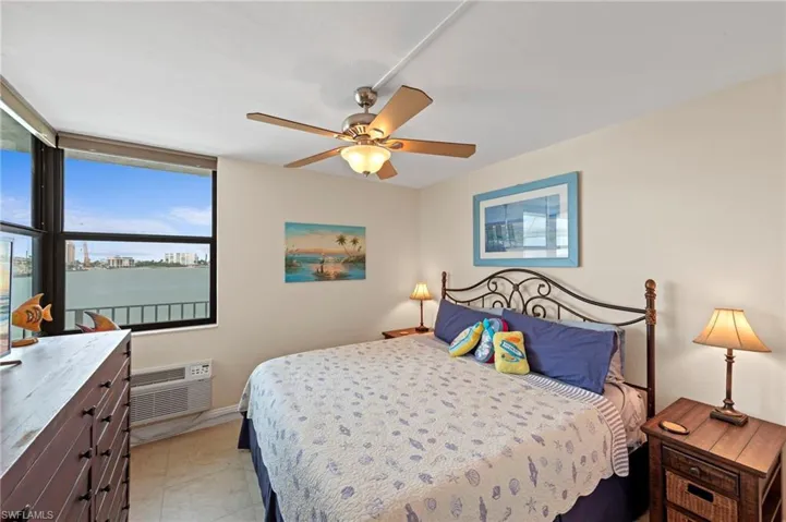 Bedroom with a ceiling fan and a wall mounted air conditioner
