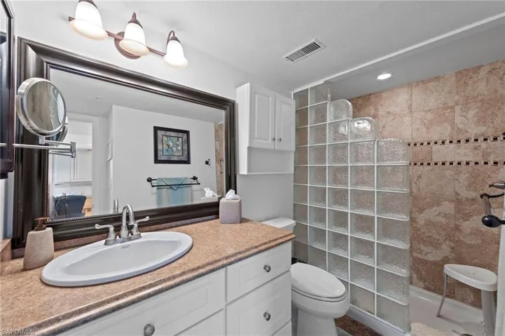 Bathroom featuring a walk in shower and vanity
