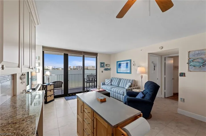 Living room featuring expansive windows, light tile patterned floors, and a ceiling fan