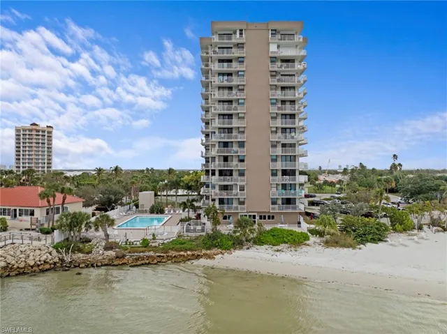 View of apartment building / complex with a water view and a community pool