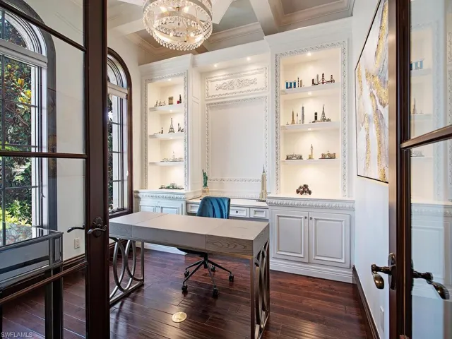 Office space with a chandelier, a wealth of natural light, ornamental molding, and dark hardwood / wood-style flooring