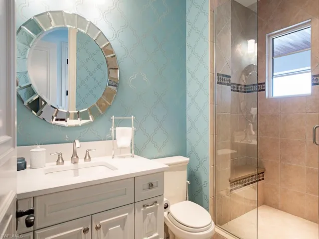 Bathroom with an enclosed shower, toilet, and large vanity