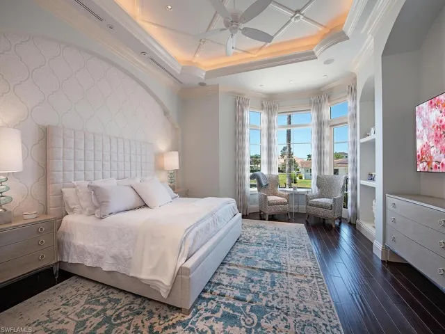 Bedroom with dark wood-type flooring, coffered ceiling, ceiling fan, and ornamental molding