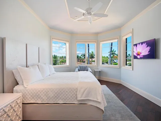 Bedroom with ornamental molding, ceiling fan, and dark hardwood / wood-style floors