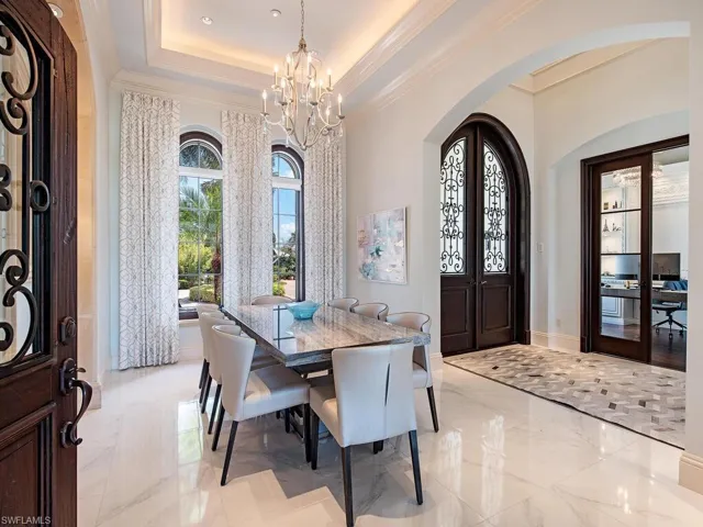 Tiled dining space with an inviting chandelier and a tray ceiling