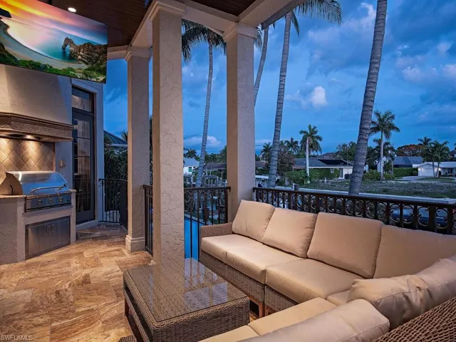 Patio terrace at dusk with an outdoor living space, exterior kitchen, and grilling area