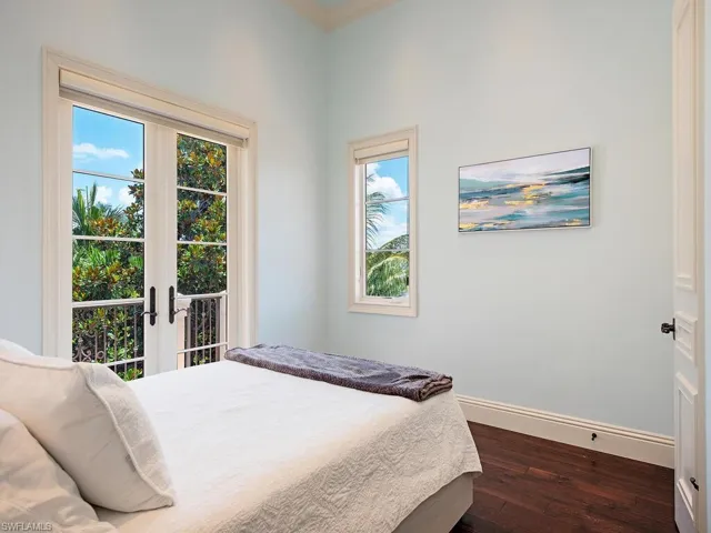 Bedroom featuring french doors, dark hardwood / wood-style floors, and multiple windows