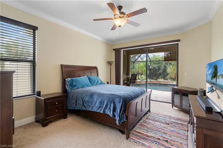 Primary bedroom featuring access to outside, crown molding, and ceiling fan