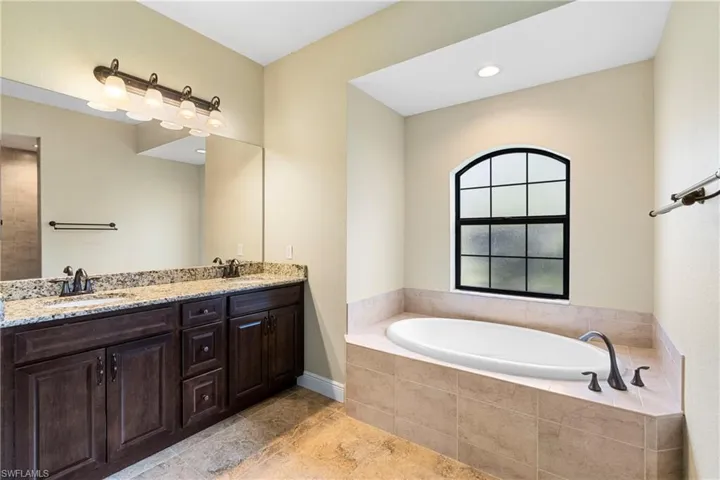 Primary Bathroom with tiled tub and vanity