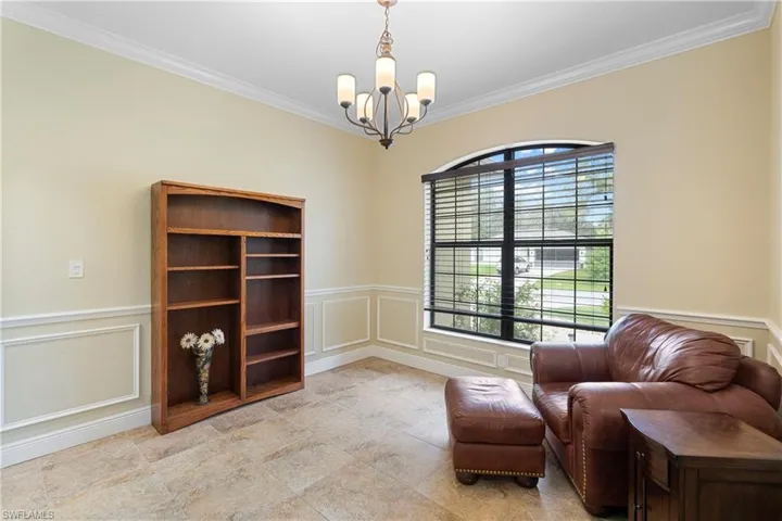 Living area with an inviting chandelier and ornamental molding