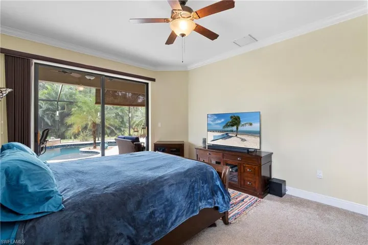 Carpeted bedroom with crown molding, ceiling fan, and access to outside
