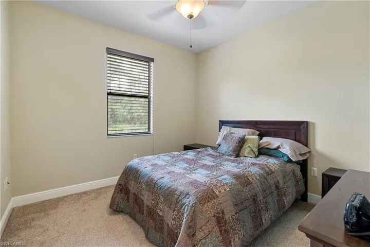 2nd Bedroom with ceiling fan and light carpet