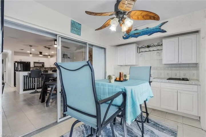 Tiled dining space featuring ceiling fan