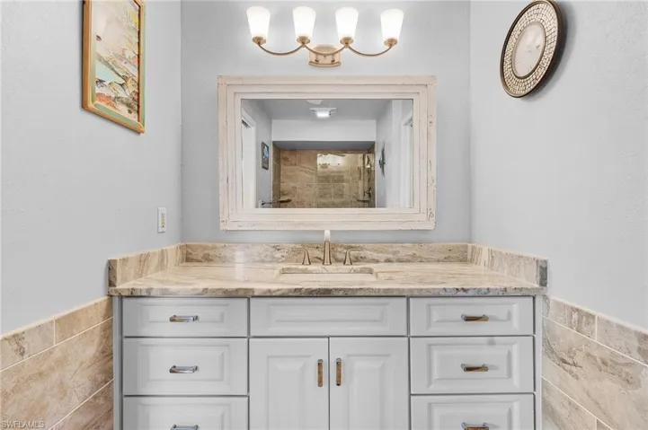 Bathroom with vanity and tile walls