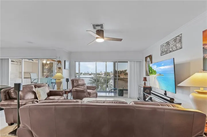 Living room featuring ceiling fan and crown molding