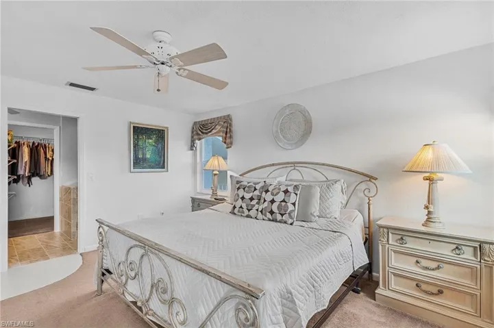 Carpeted bedroom with a closet, ceiling fan, and a walk in closet
