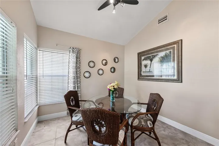Dining area featuring baseboards, visible vents, lofted ceiling, and ceiling fan