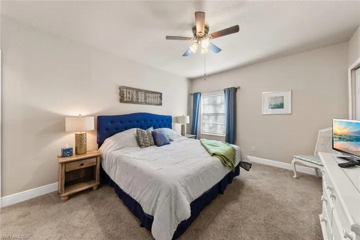 Bedroom with baseboards, a ceiling fan, and light carpet