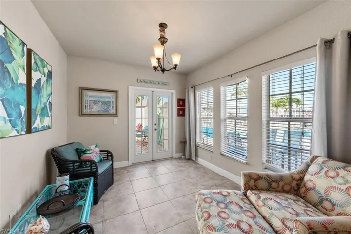 Entryway featuring baseboards, an inviting chandelier, french doors, and light tile patterned floors