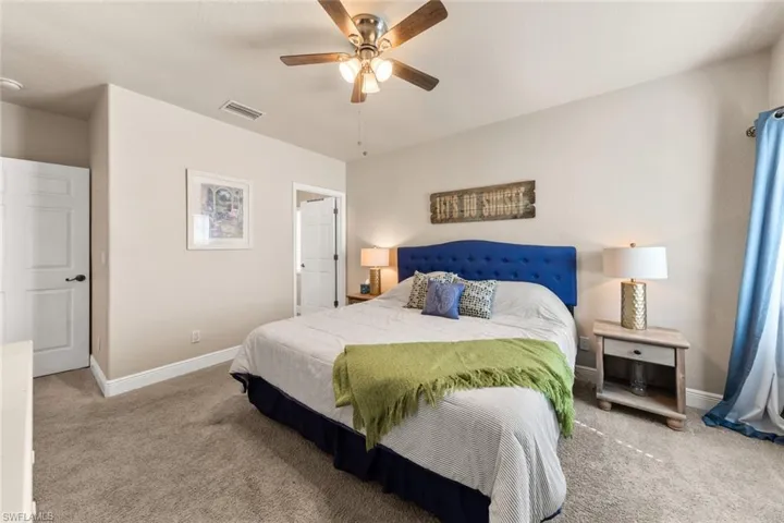 Bedroom with baseboards, visible vents, and carpet flooring