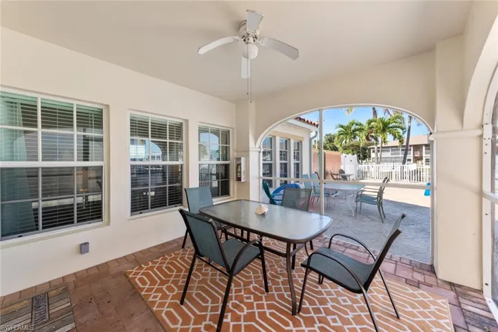 View of patio with outdoor dining space, ceiling fan, and fence