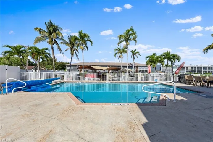 Community pool featuring a patio and fence
