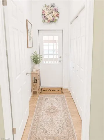 Entryway featuring light wood-finish flooring, white paneled door