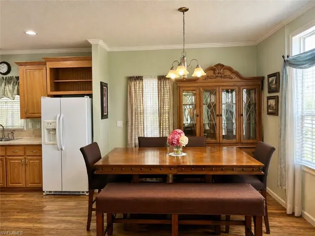 Dining area featuring wood-finish flooring and crown molding