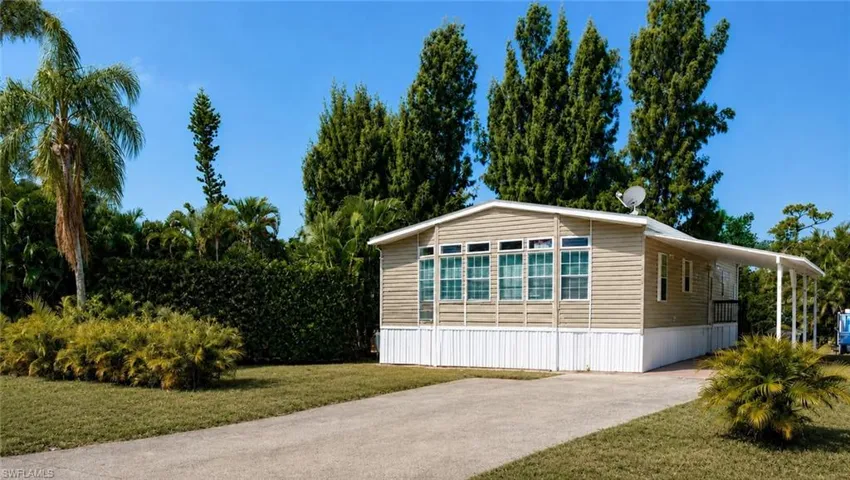 Single-story property featuring tan horizontal siding and white skirting