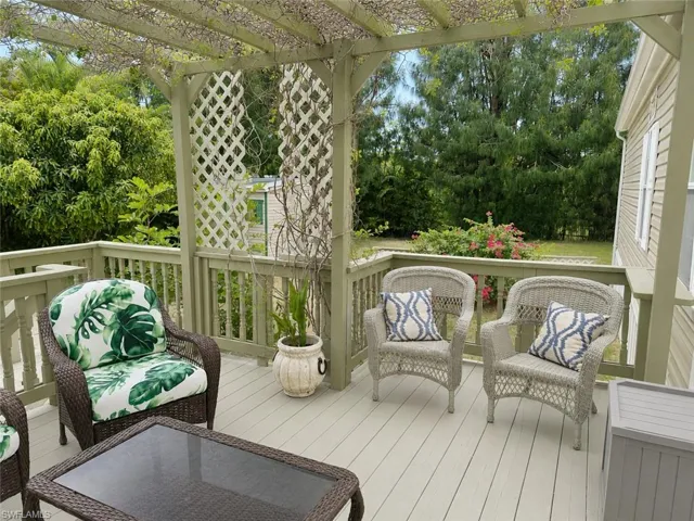 Spacious outdoor deck featuring a wooden pergola, lattice accents, and perimeter railing
