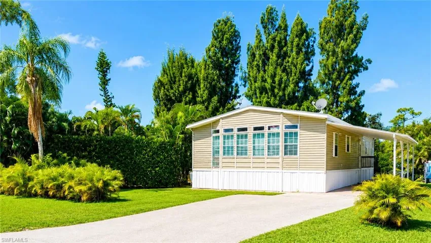 Tan siding exterior with white trim and a carport