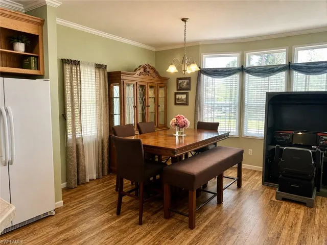 Dining area featuring wood-finish flooring and crown molding