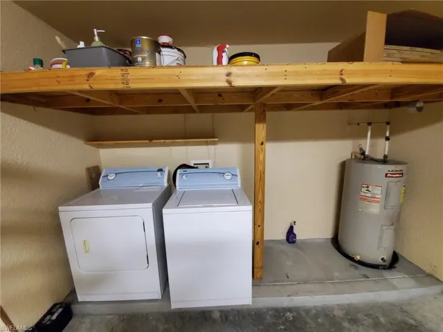 Washroom featuring electric water heater and independent washer and dryer