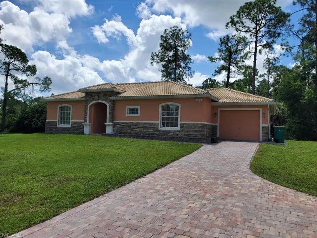Mediterranean / spanish-style house featuring a garage and a front lawn