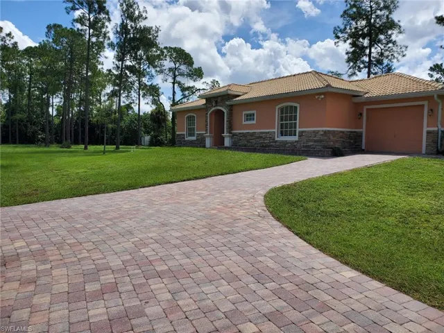 Mediterranean / spanish-style home with a garage and a front lawn