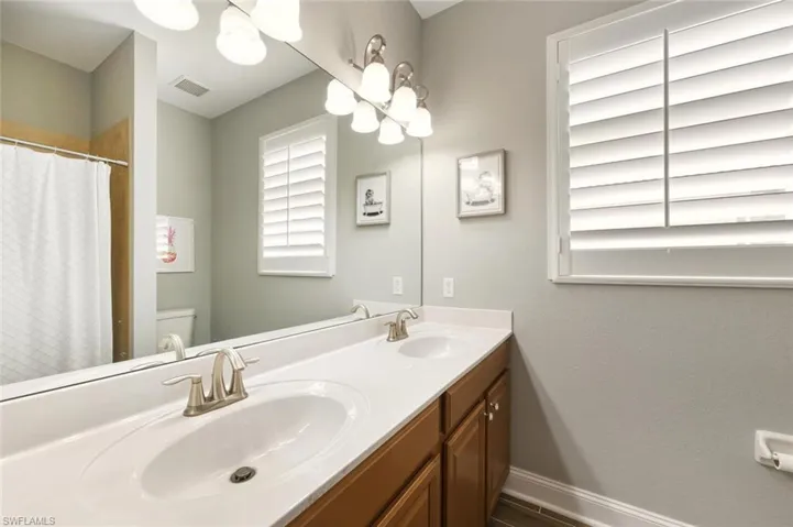 Bathroom with double vanity and a shower with curtain