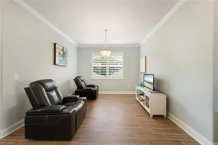 Living area with wood finish floors and crown molding