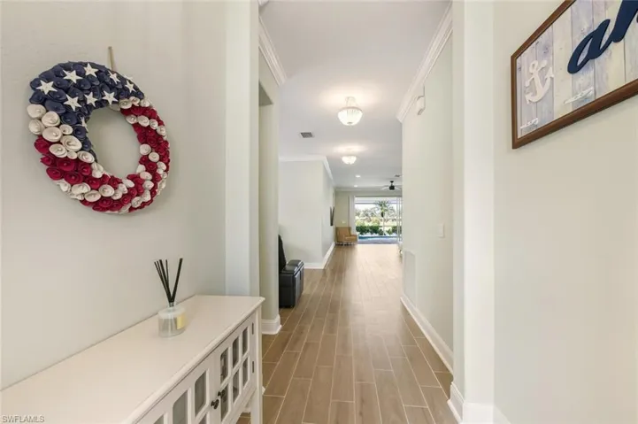 Hallway with crown molding and tile floors