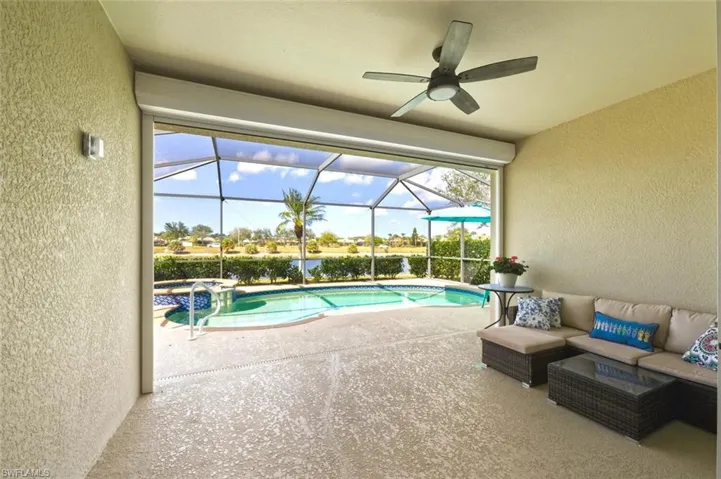 Combined pool / hot tub with a sunroom, glass enclosure, an outdoor lounge area, a patio, and a water view