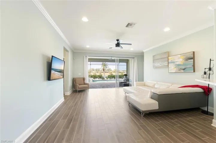 Living room featuring wood tiled floors, a ceiling fan, recessed lighting, and crown molding