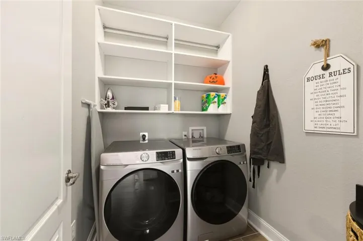 Laundry room with independent washer and dryer and baseboards