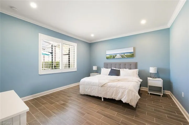 Bedroom featuring wood tile floors, ornamental molding, and recessed lighting