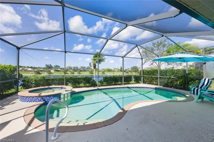 Relaxing pool / spa featuring a sunroom, a water view, a lanai, and a patio area