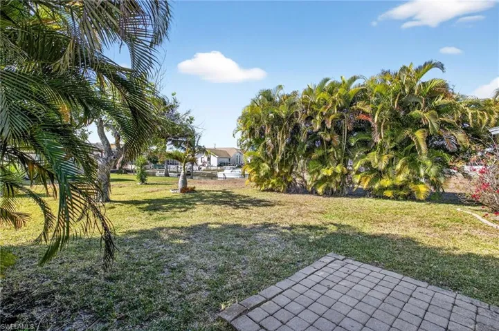 View of grassy yard with a patio area