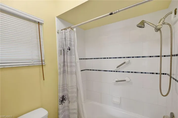 Full bath featuring shower / bathtub combination with curtain and toilet