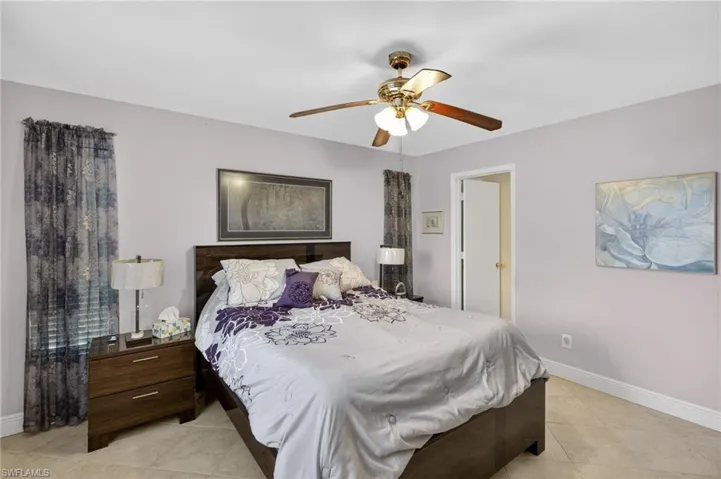 Bedroom with ceiling fan and light tile patterned flooring